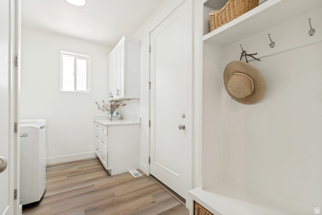 683 Kings Landing Tooele, UT 84074 - Photo 14 of 39 Dedicated laundry area featuring wood-finish flooring, white cabinetry, a countertop, and a built-in bench with shelving and hooks
