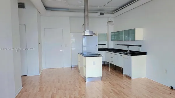 a kitchen with granite countertop a stove and white cabinets