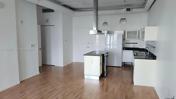 a kitchen with a refrigerator and a stove top oven