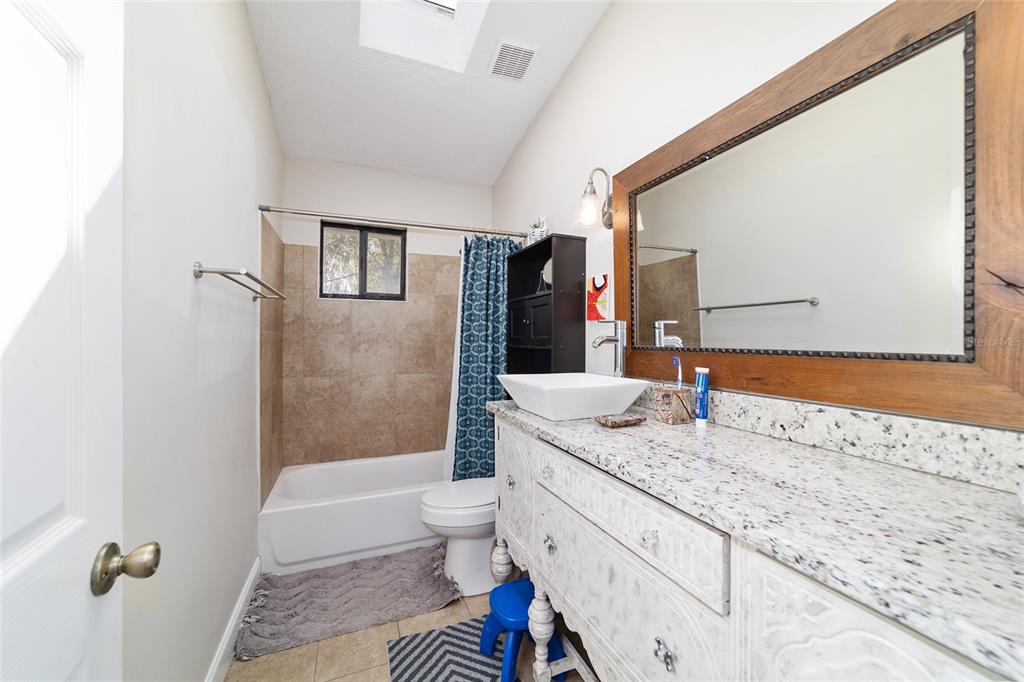 3510 Southwest 5th Court Ocala, FL 34471 - Photo 31 of 44 a bathroom with a granite countertop sink mirror vanity and toilet