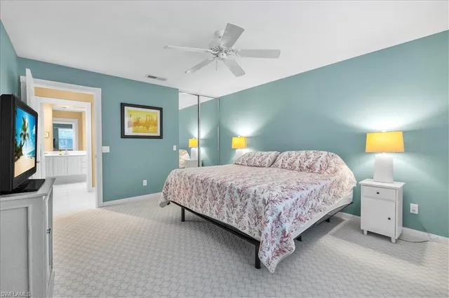 a bedroom with a bed and a flat tv screen on dresser