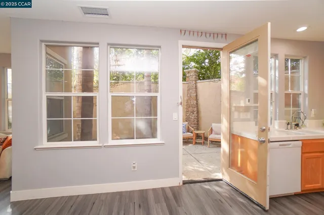a view of a room with a large window and wooden floor