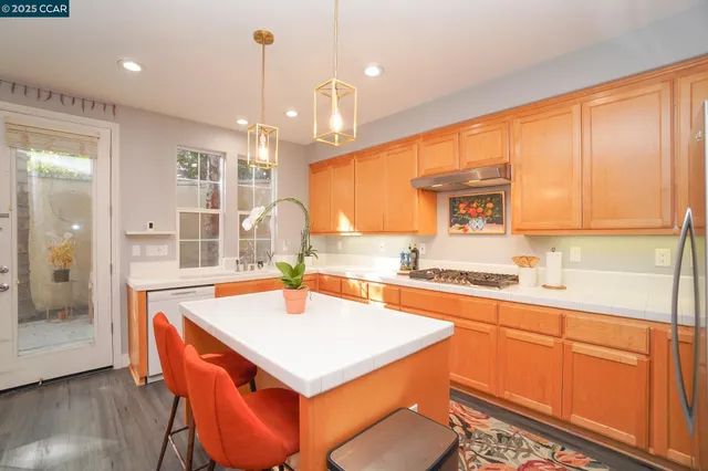 a kitchen with a sink a stove a refrigerator and wooden cabinets