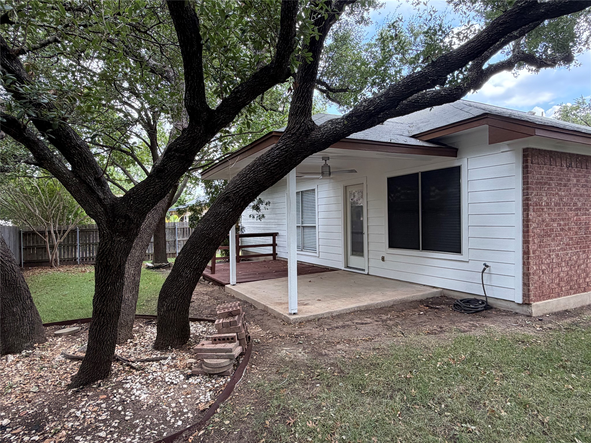 4604 Ramies Run Austin, TX 78749 - Photo 36 of 38 Mature trees shade a quiet covered patio alongside a classic brick and siding exterior.