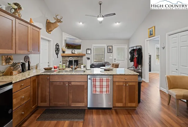 a kitchen with stainless steel appliances granite countertop wooden floors and sink