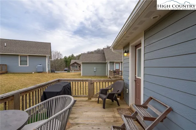 a view of a roof deck with table and chairs with wooden floor and fence