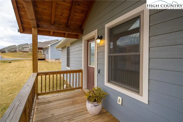 a view of a balcony with chair and floor to ceiling window with wooden floor
