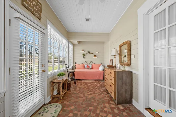 a bedroom with furniture and a large window