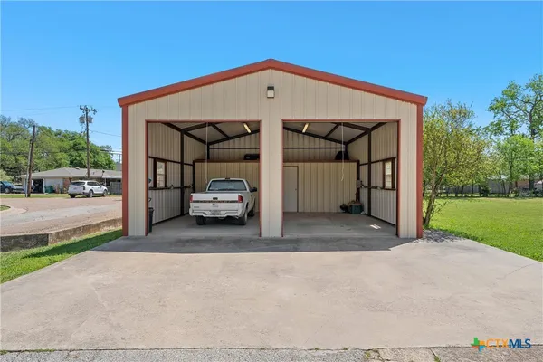 a view of a car parked in front of a house with a yard