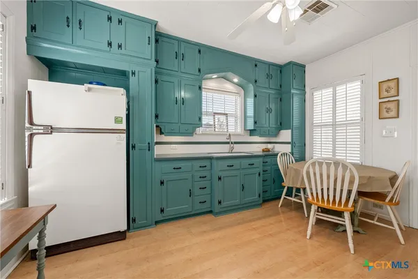 a kitchen with cabinets and a refrigerator