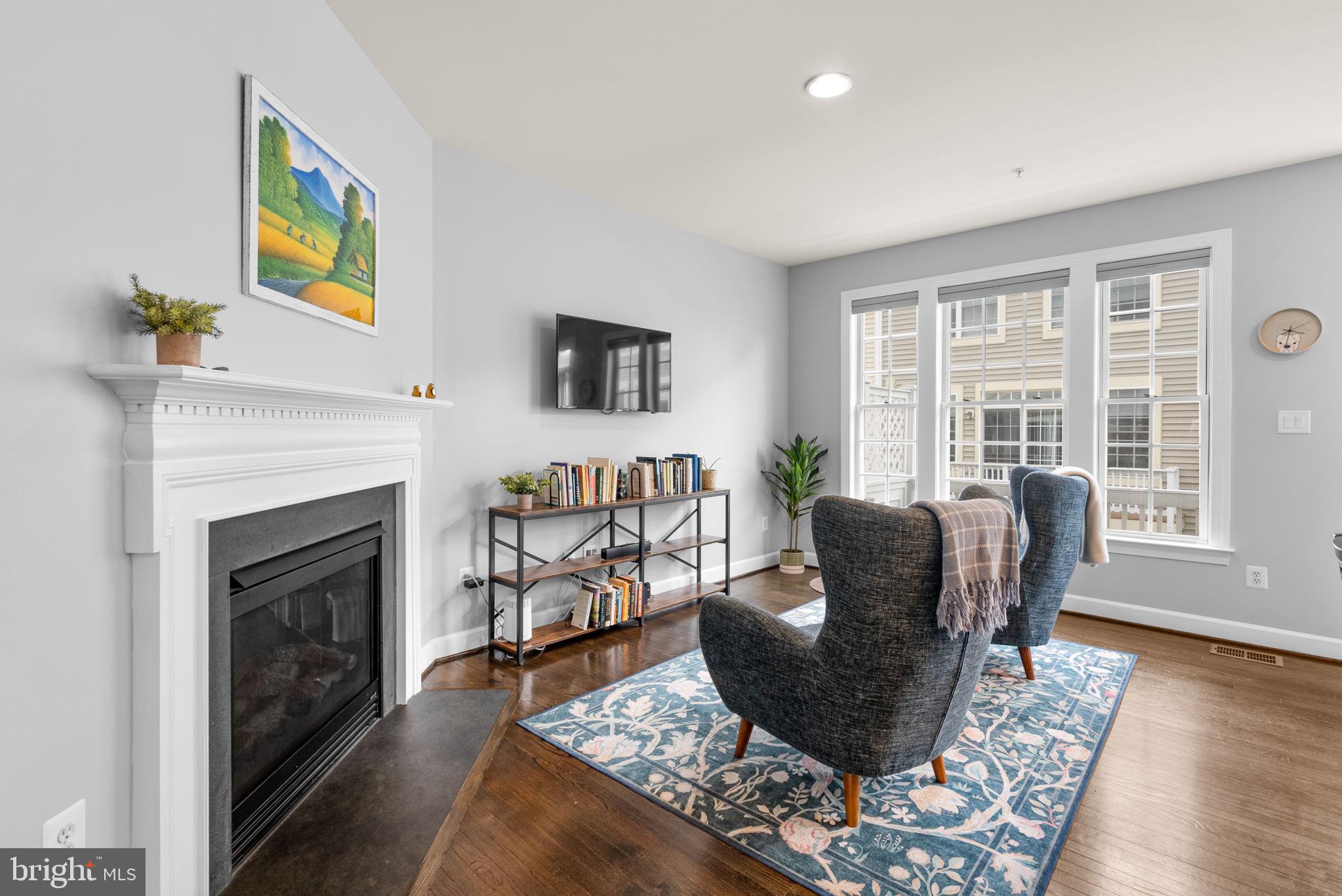 1222 Gaither Road Rockville, MD 20850 - Photo 13 of 42 a living room with furniture a flat screen tv and a fireplace