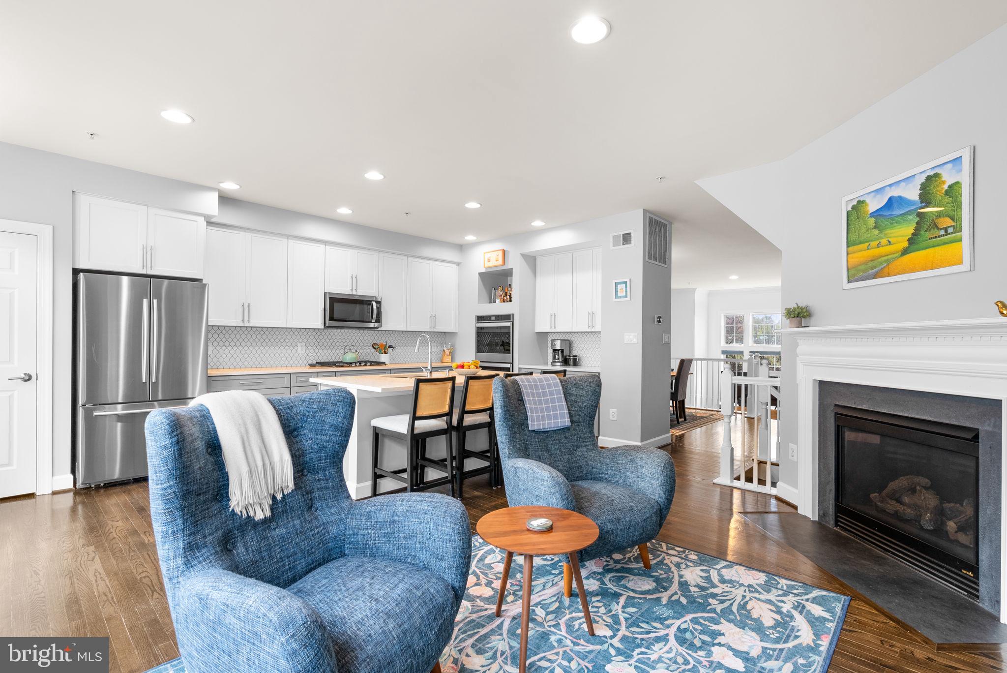1222 Gaither Road Rockville, MD 20850 - Photo 14 of 42 a living room with furniture kitchen view and a fireplace