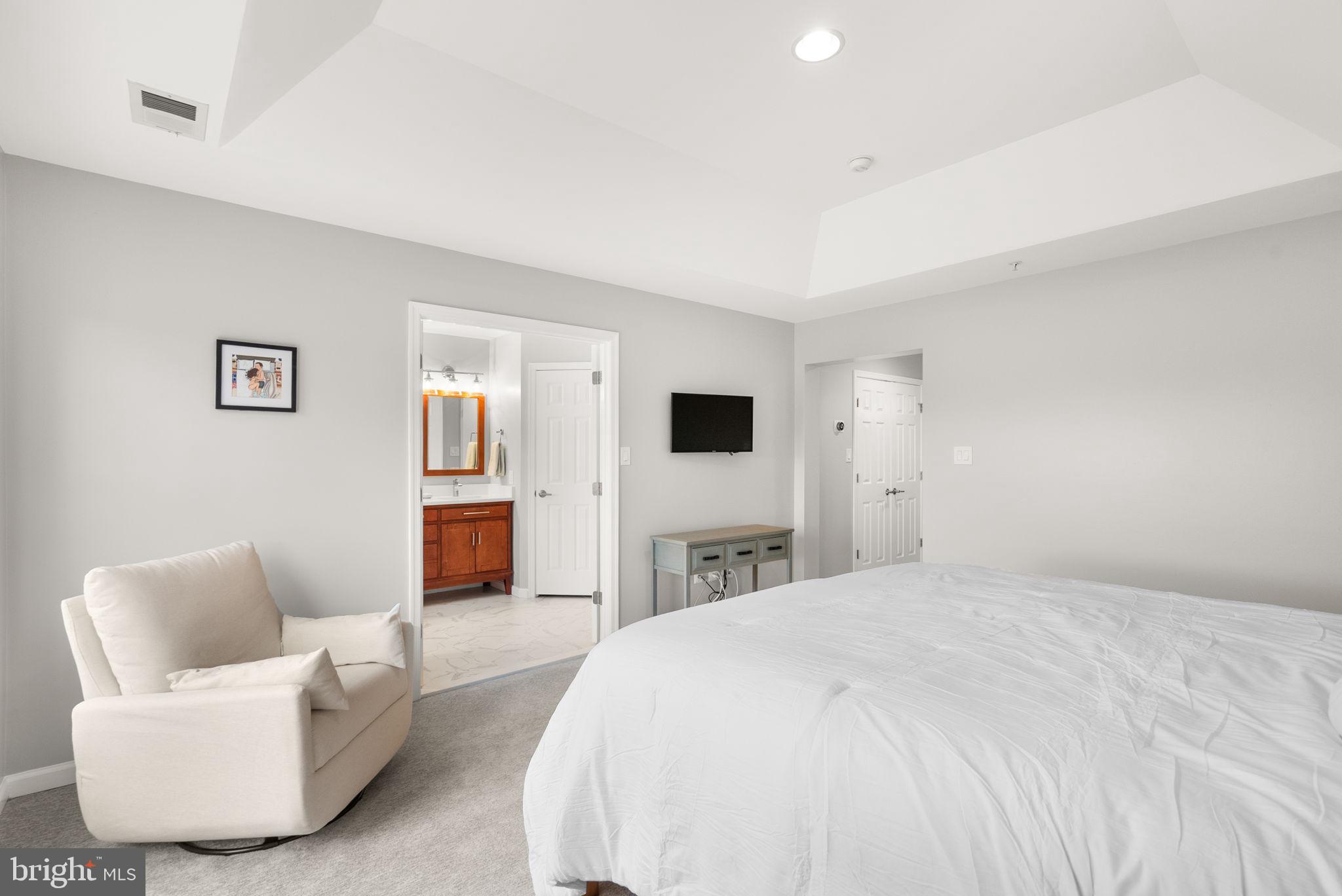 1222 Gaither Road Rockville, MD 20850 - Photo 17 of 42 a spacious bedroom with a bed and a couch