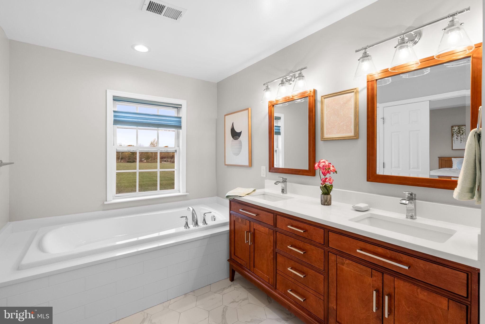 1222 Gaither Road Rockville, MD 20850 - Photo 18 of 42 a bathroom with a tub double sink mirror and
