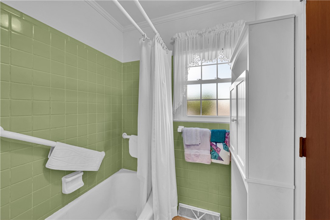 307 Calhoun Road Belton, SC 29627 - Photo 21 of 30 A well-lit bath features green tiled walls and a functional window.