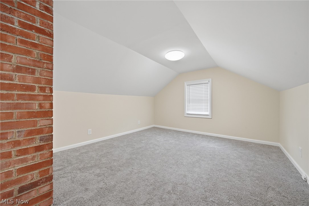 2231 Brockway Road University Heights, OH 44118 - Photo 28 of 46 Spacious room featuring sloped ceilings, a window with blinds, and light-colored walls