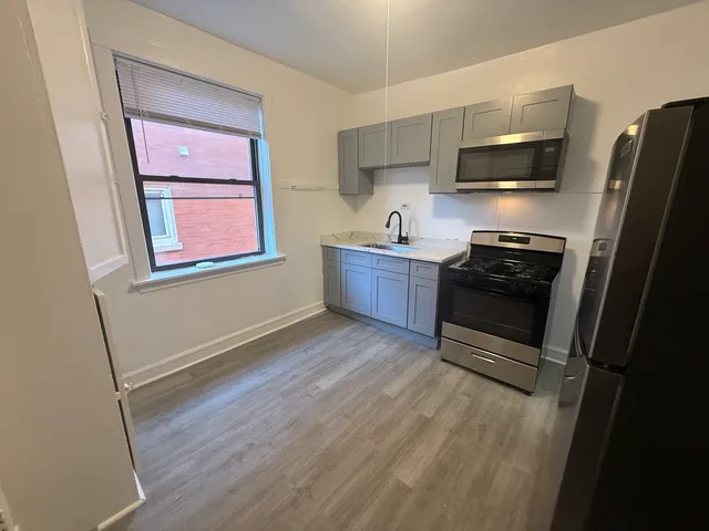 a kitchen with stainless steel appliances a stove refrigerator and microwave