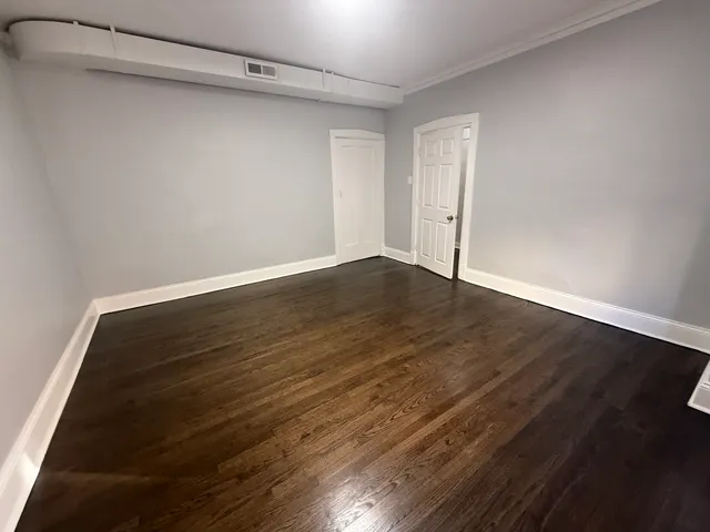 a view of an empty room with wooden floor