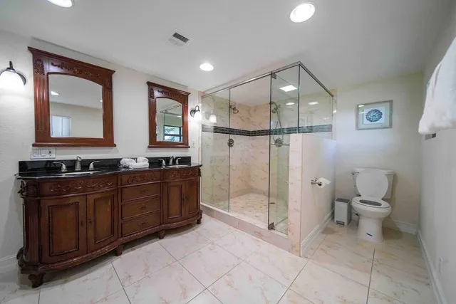 a spacious bathroom with a sink a toilet and a mirror
