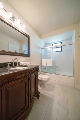 a bathroom with a sink a toilet and shower