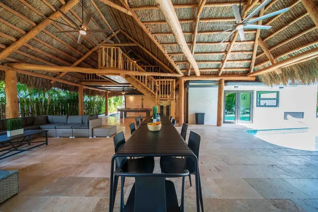 a view of a patio with table and chairs under an umbrella with a big yard
