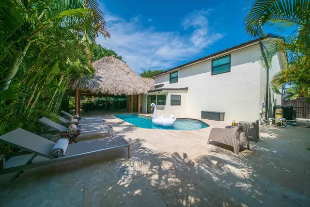 a view of a patio with table and chairs potted plants and palm tree
