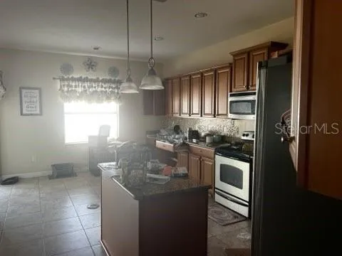a kitchen with stainless steel appliances granite countertop a sink and a refrigerator