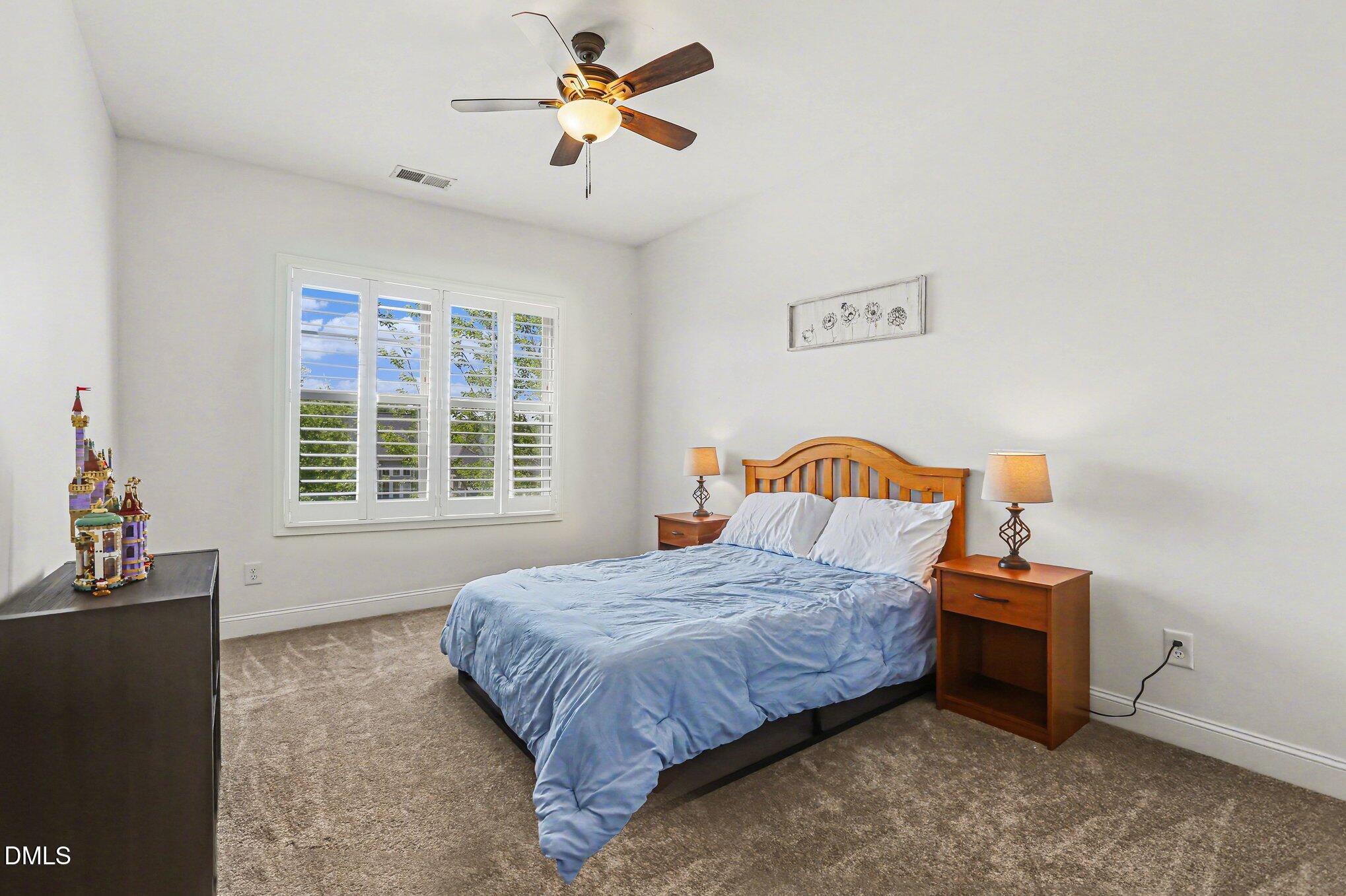 432 Seabring Lane Raleigh, NC 27603 - Photo 17 of 29 a bedroom with a bed and a chandelier
