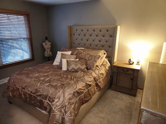a bedroom with a bed and a window