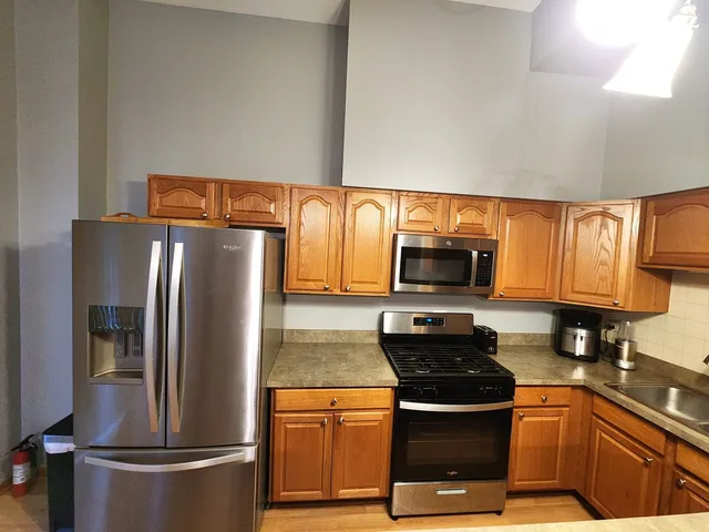a kitchen with stainless steel appliances granite countertop a refrigerator stove and microwave