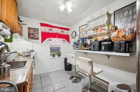 a kitchen with a refrigerator a stove a sink and a dining table with garden view