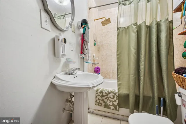 a bathroom with a sink a toilet and shower curtain