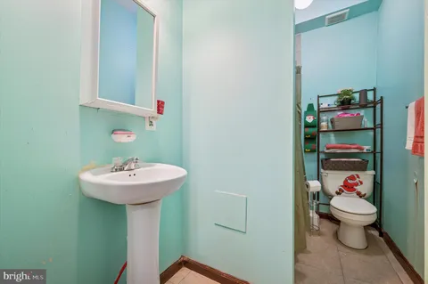 a bathroom with a sink toilet and a mirror