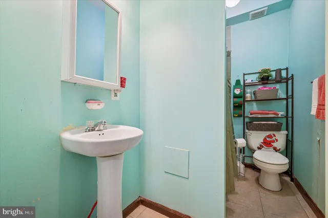 a bathroom with a sink toilet and a mirror