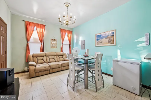 a living room with furniture a chandelier and a dining table