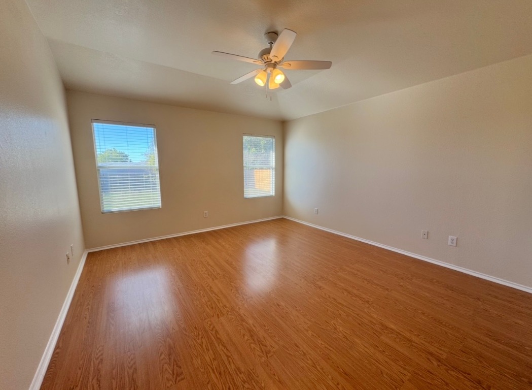 104 Gettysburg Loop Elgin, TX 78621 - Photo 12 of 26 Empty room with light wood-style floors and ceiling fan