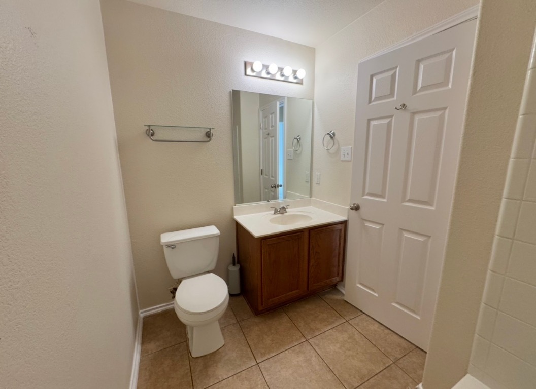 104 Gettysburg Loop Elgin, TX 78621 - Photo 19 of 26 Bathroom featuring vanity, a textured wall, and light tile patterned floors