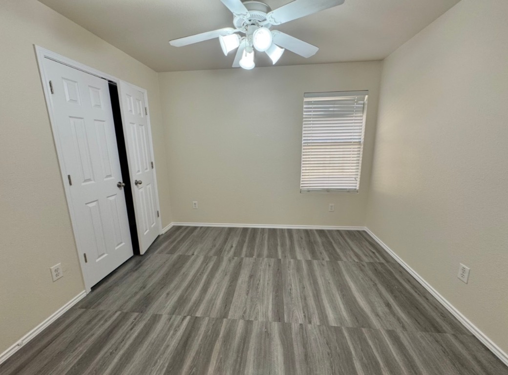 104 Gettysburg Loop Elgin, TX 78621 - Photo 21 of 26 Unfurnished bedroom featuring wood finished floors, a ceiling fan, and a closet