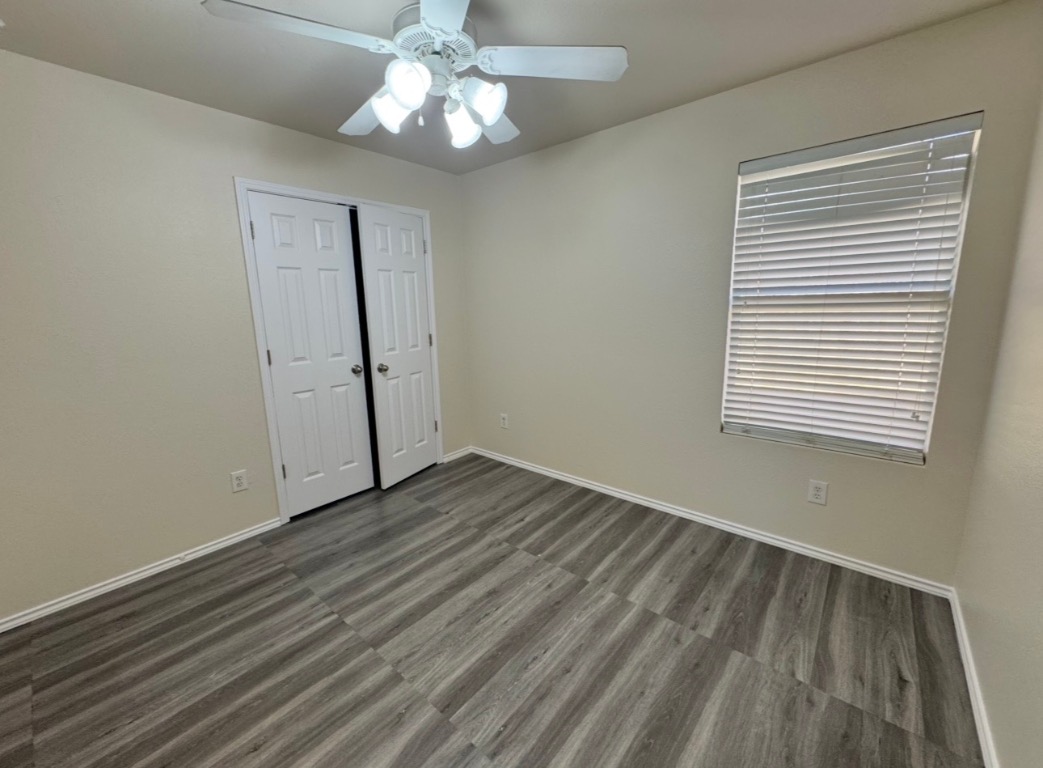 104 Gettysburg Loop Elgin, TX 78621 - Photo 22 of 26 Unfurnished bedroom with ceiling fan, a closet, and dark wood-style flooring