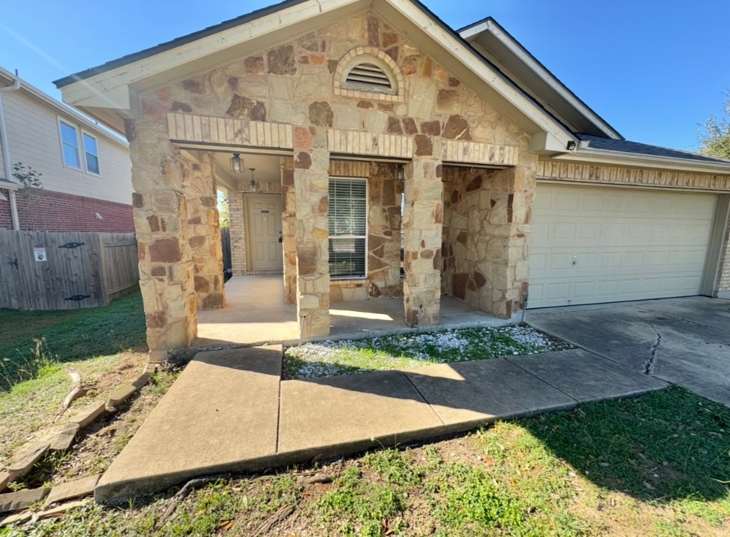 104 Gettysburg Loop Elgin, TX 78621 - Photo 6 of 26 View of front of home featuring stone siding, concrete driveway, and a porch