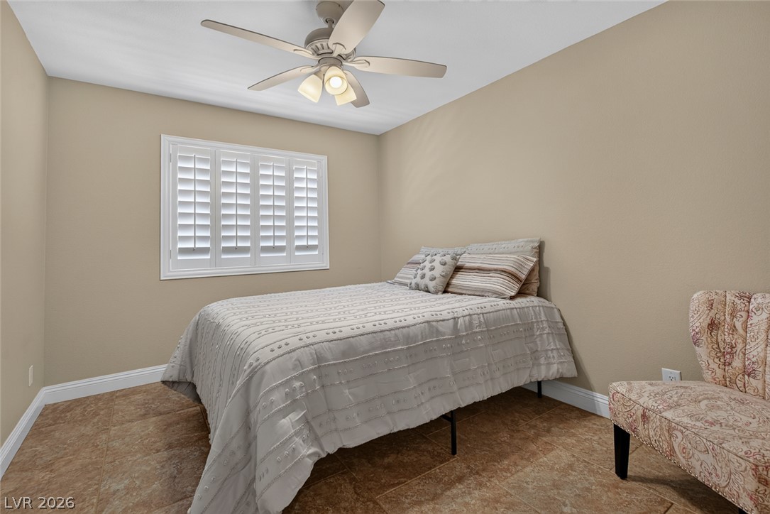 818 Manor Shores Road Henderson, NV 89002 - Photo 22 of 35 A quiet bedroom featuring plantation shutters and a ceiling fan for optimal comfort.
