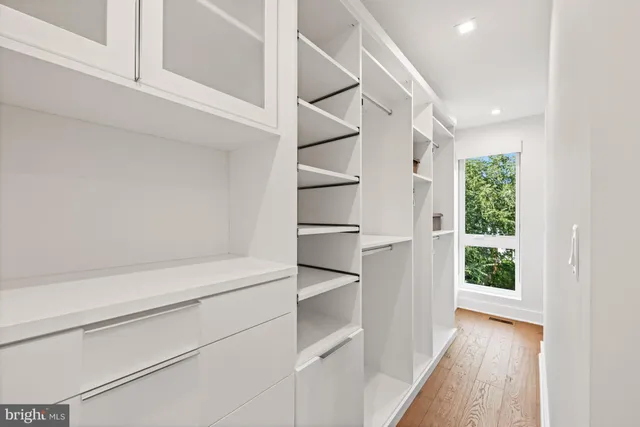 a view of walk in closet with empty racks