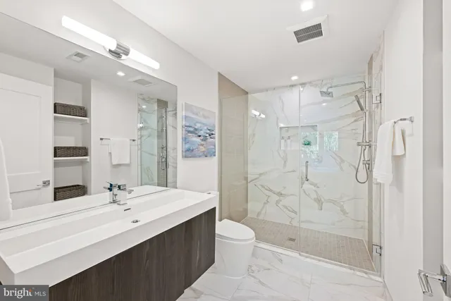 a bathroom with a bathtub shower sink mirror and toilet