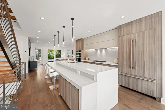 a kitchen with kitchen island a stove a sink a microwave and wooden floor