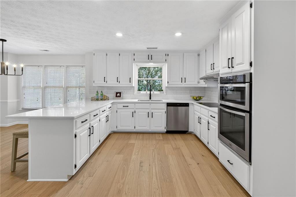 601 Cobblestone Lane Stone Mountain, GA 30087 - Photo 22 of 69 a kitchen with white cabinets appliances a sink and a window