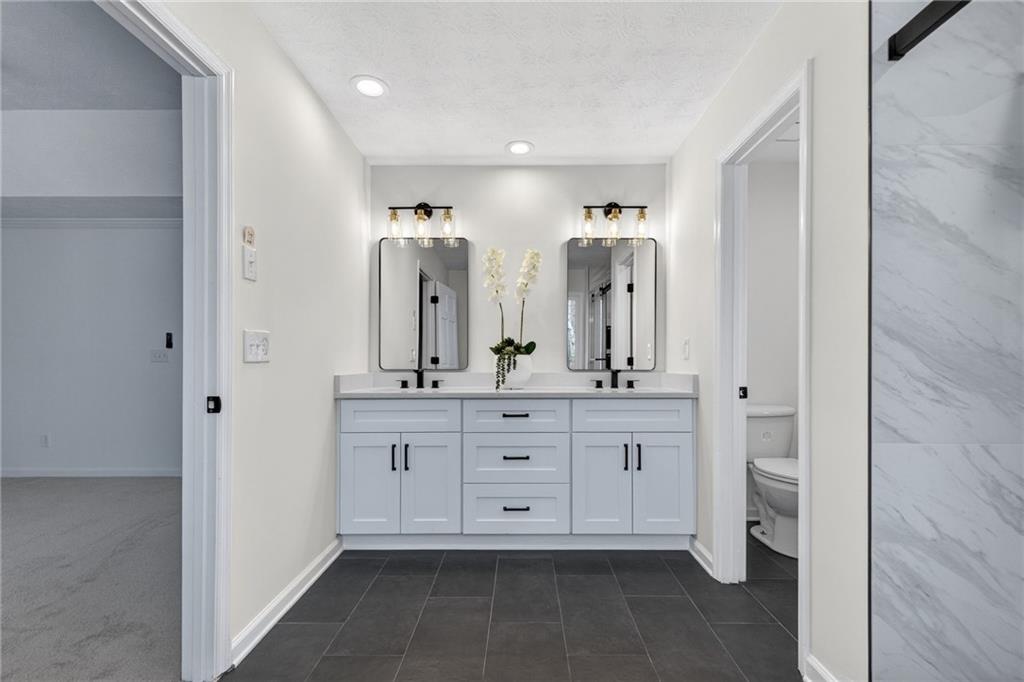 601 Cobblestone Lane Stone Mountain, GA 30087 - Photo 38 of 69 a spacious bathroom with a granite countertop sink a mirror and a