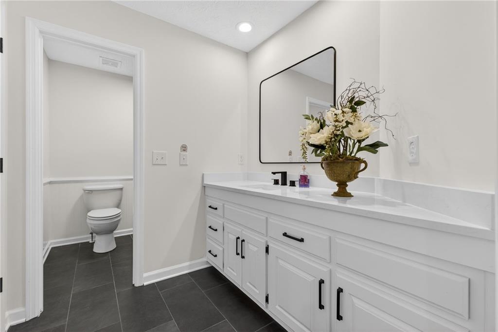 601 Cobblestone Lane Stone Mountain, GA 30087 - Photo 42 of 69 a bathroom with a sink and mirror with toilet