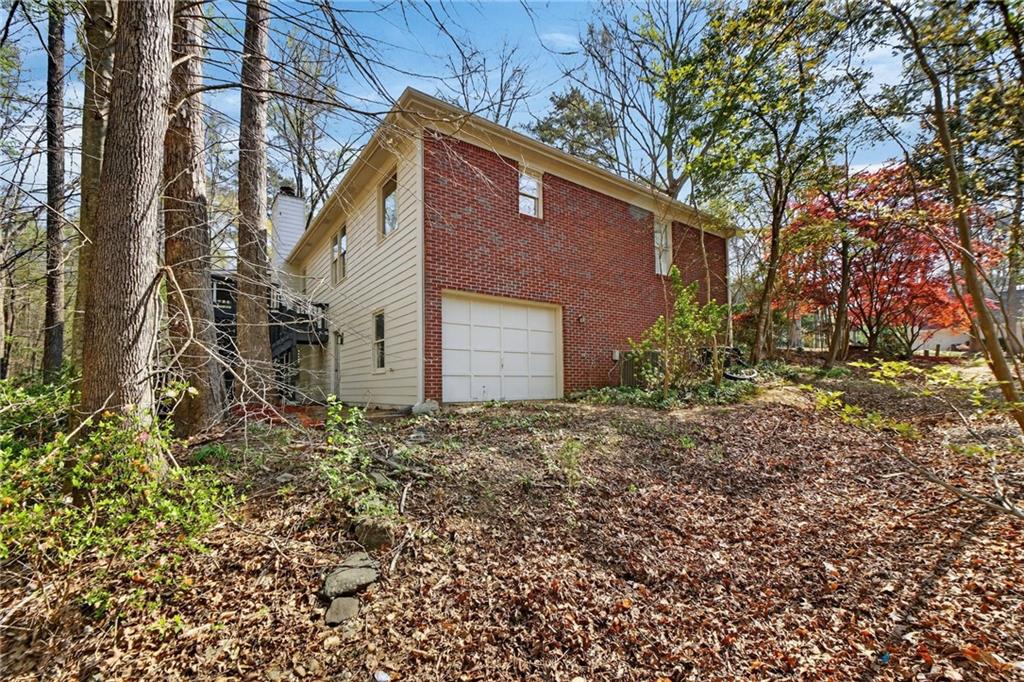601 Cobblestone Lane Stone Mountain, GA 30087 - Photo 56 of 69 a backyard of a house with plants and large tree