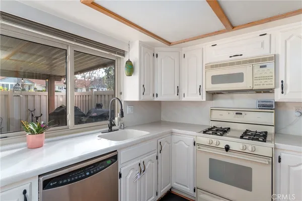 a kitchen with stainless steel appliances white cabinets and a stove top oven