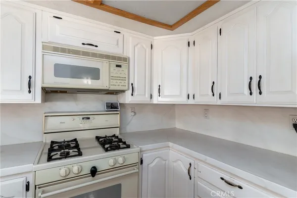 a kitchen with white cabinets and appliances